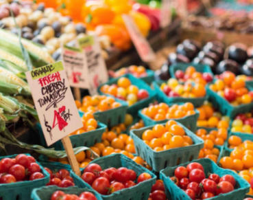 Brightly colored vegetables are sitting in cartons in a market