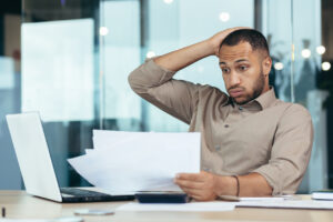 Worried African American man holding papers in hands
